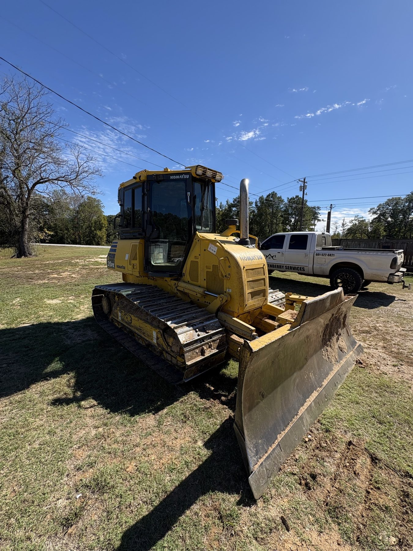 Dozer with its blade down on a grassy lot